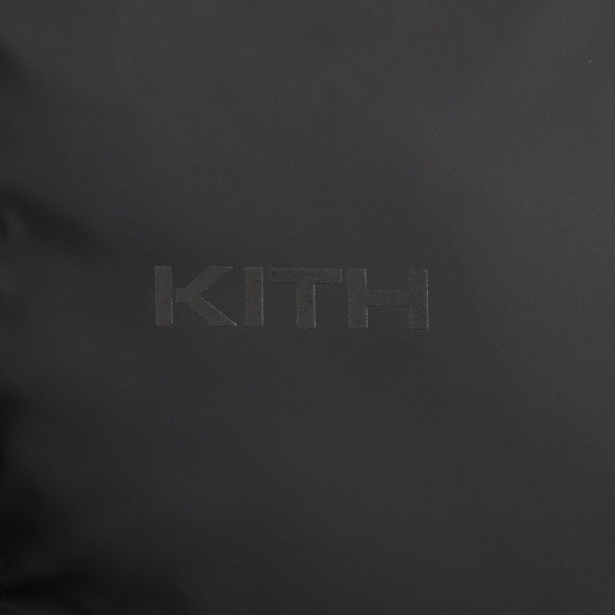 Close-up of the asymmetric zip on the black Stretch Poly Filmore puffer