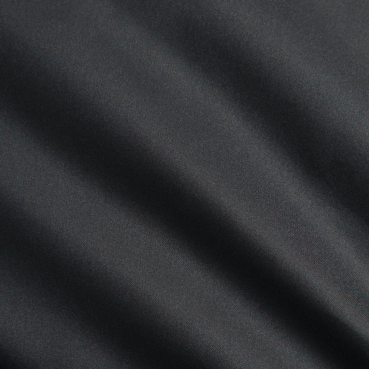 Close-up of black matte taffeta fabric of the Kith midi puffer