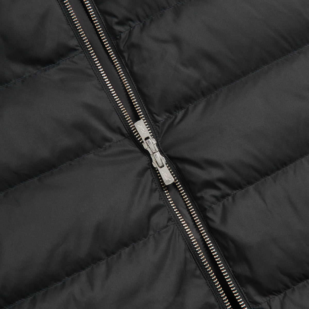 Close-up of the two-way zip on the black Matte Stretch Taffeta Cameron puffer