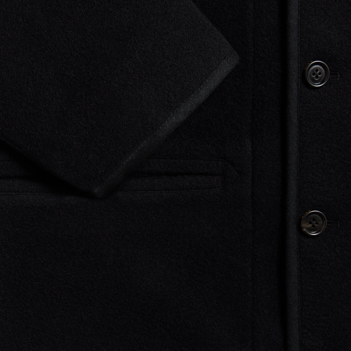 Close-up of the welt pocket and buttons on the black &Kin Bowie jacket