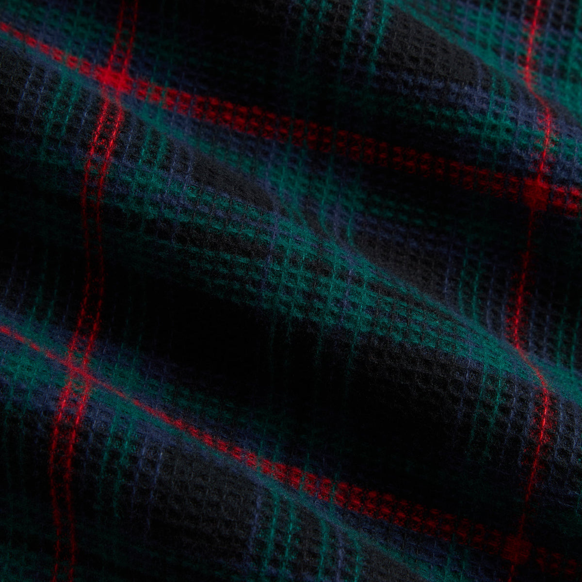 Close-up of the navy, green and red plaid waffle fabric of the Kith Tomas shirt