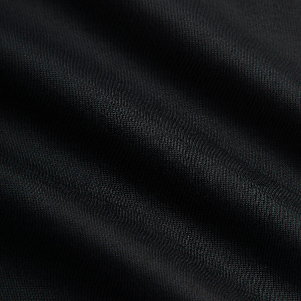 Close-up of black interlock knit fabric of the &Kin Cyrus turtleneck