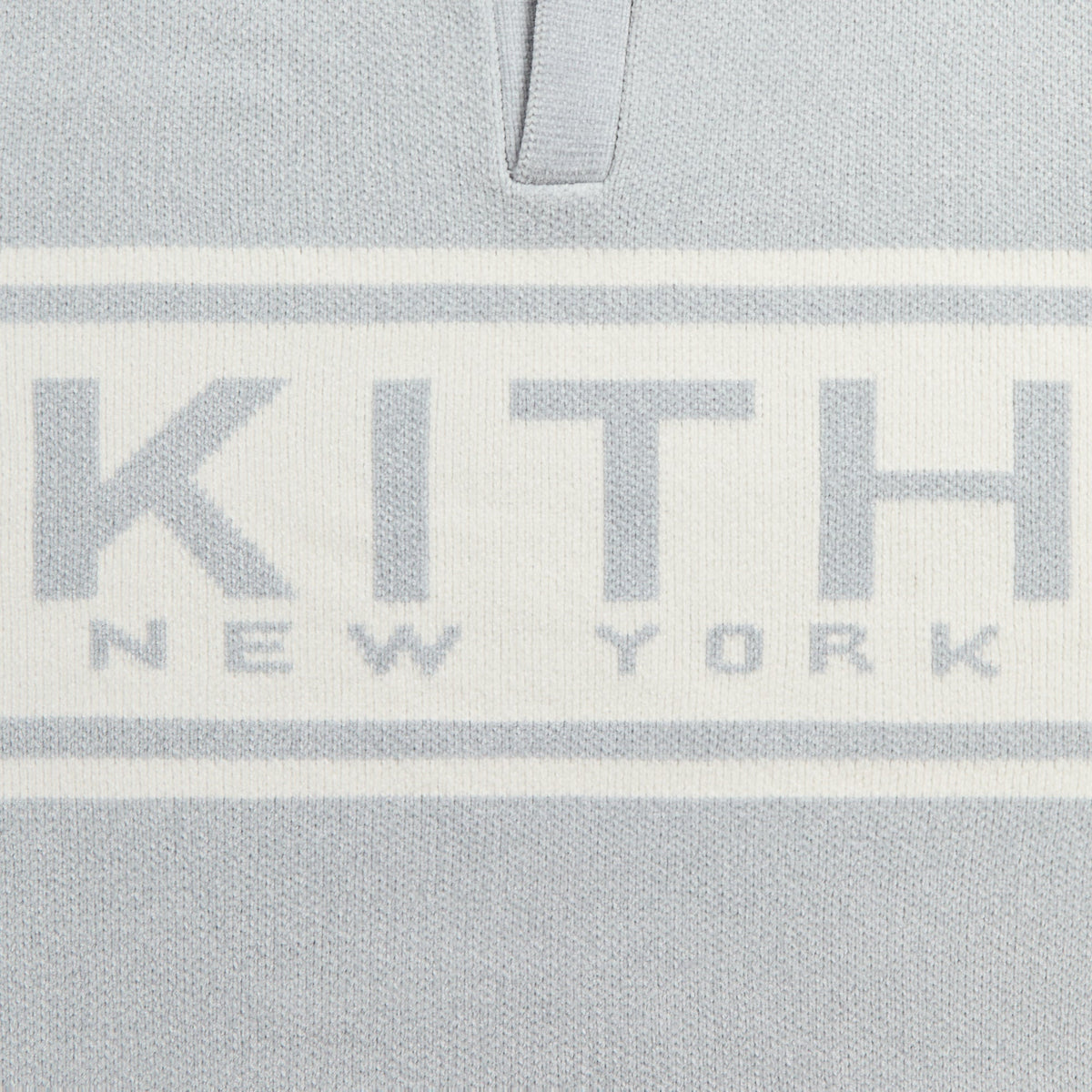 Close-up of the 'KITH New York' intarsia on the chest of the light grey Nelson rugby sweater