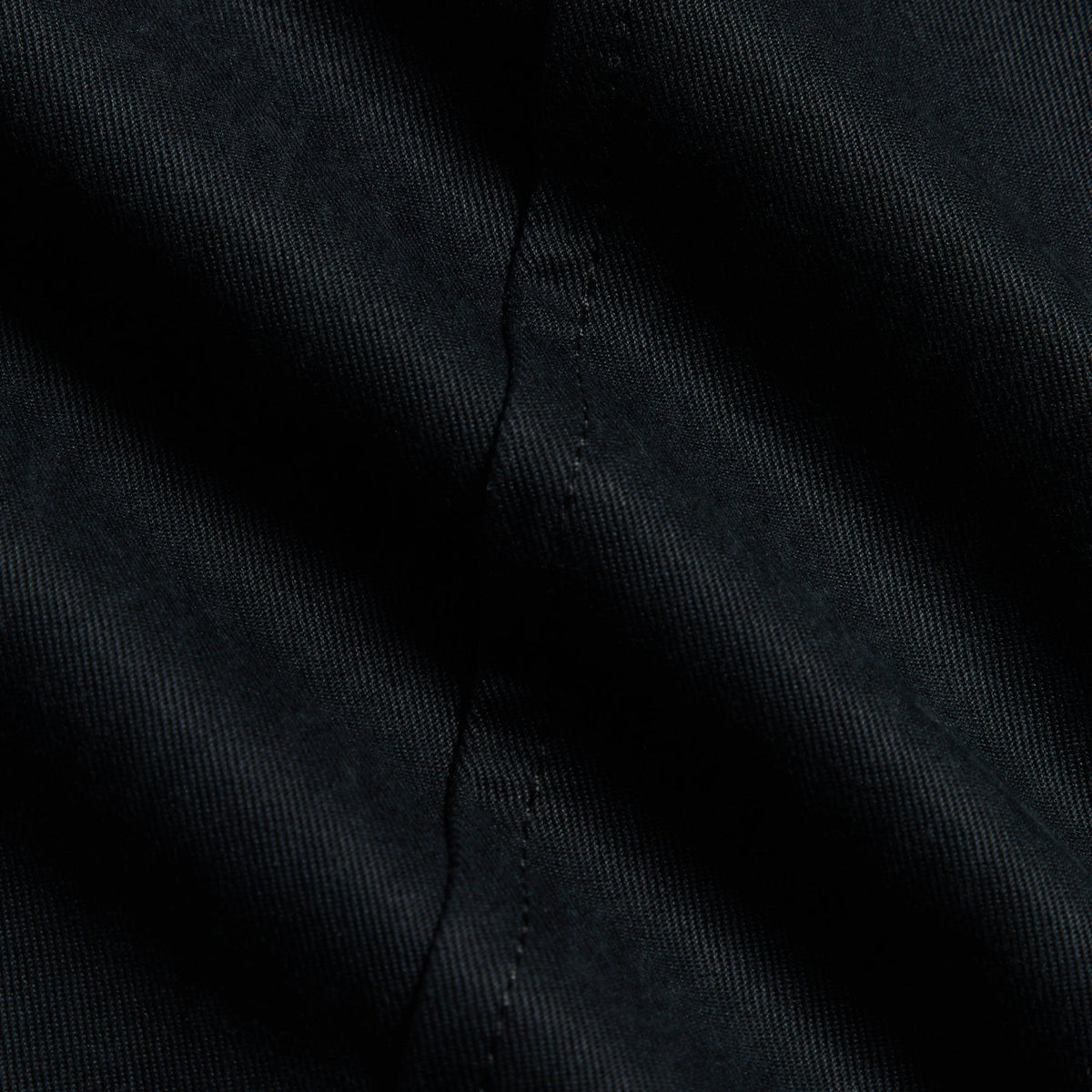 Close-up of black washed herringbone twill fabric of the Kith Gus pant