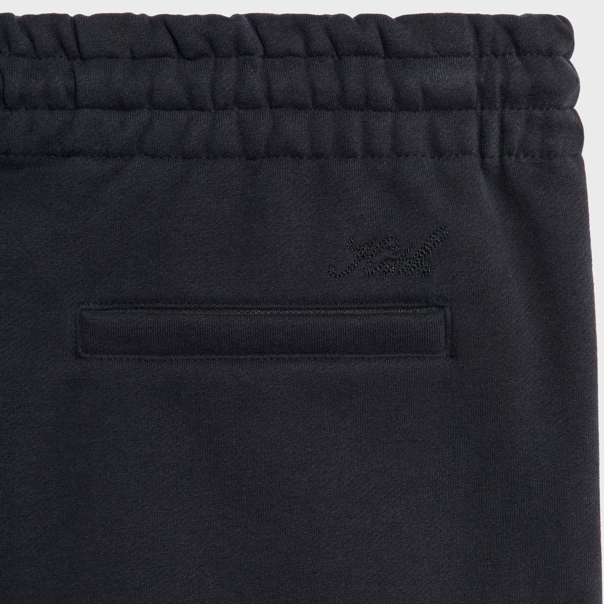 Close-up of the back welt pocket and tonal logo on the black Sueded French Terry Bryson sweatpant